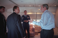 President George W. Bush is briefed by staff about the on going terrorist attack aboard Air Force One after departing Sarasota, Florida Tuesday, Sept. 11, 2001. 