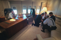 President George W. Bush talks on the telephone Tuesday, Sept. 11, 2001, as senior staff huddle aboard Air Force One. 