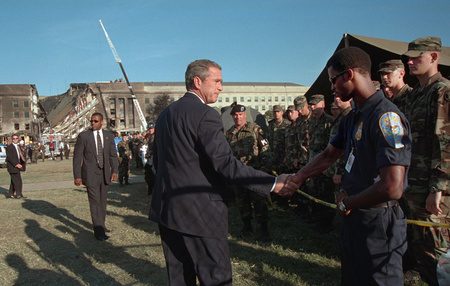 President George W. Bush greets rescue workers, firefighters and military personnel Wednesday, Sept. 12, 2001, while surveying damage caused by the previous day's terrorist attacks on the Pentagon in Arlington, Va.